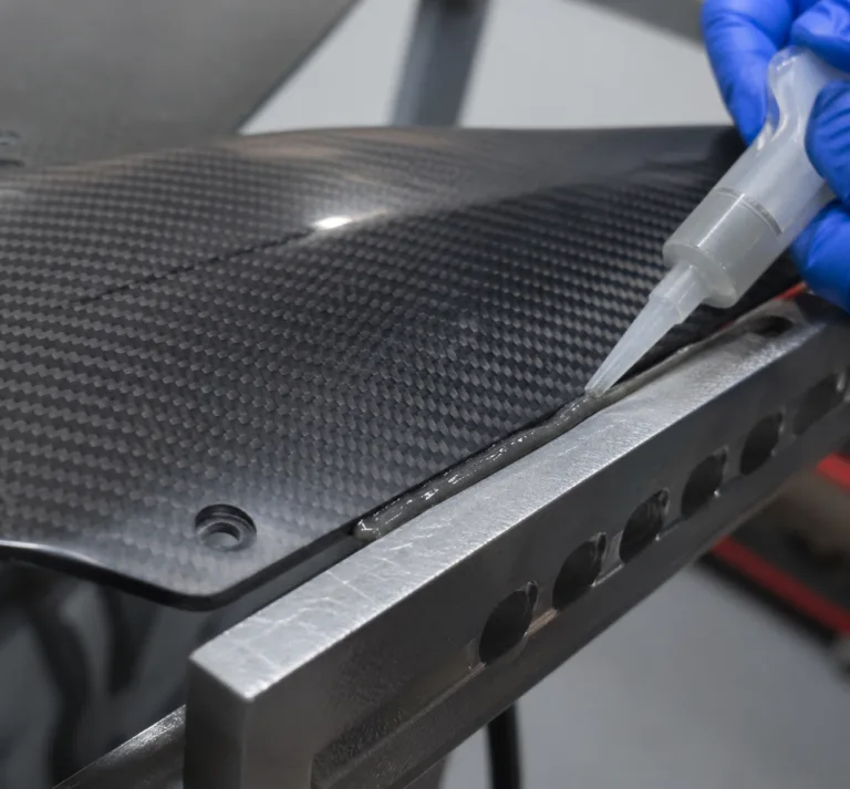 Material 12 Realistic product photography showing high-performance adhesive bonding of carbon fiber components, with detailed materials, clean composition, and no text or watermark.