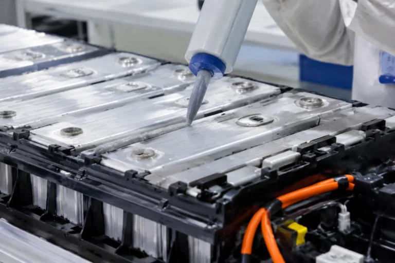 Thermally Conductive Adhesive 4 A detailed close-up of thermal adhesive application inside a battery module or pack, shown in a clean new energy manufacturing environment with professional product photography style.