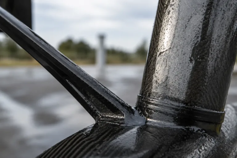 Carbon Fiber Adhesive 17 A clean, realistic industrial testing scene featuring bonded carbon fiber assemblies exposed to conditions that represent humidity, heat, oils, UV, and outdoor service, highlighting durability and reliability.