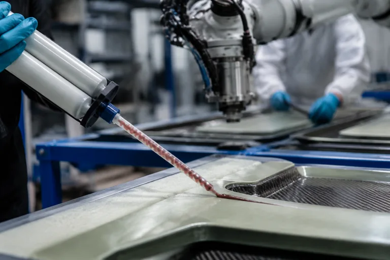 Composite Adhesive 15 A realistic advanced manufacturing scene showing composite adhesive selection and application, with a dispensing cartridge, static mixing nozzle, robotic application, and panel assembly workflow.