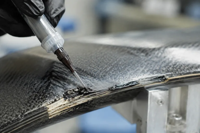 Composite Adhesive 8 A realistic close-up scene showing composite repair adhesive applied to a damaged edge and weak area for technical restoration.