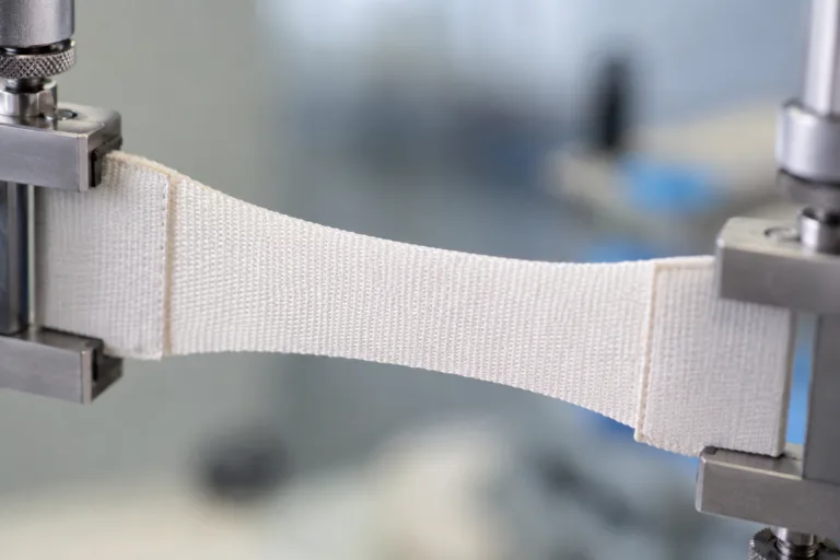 Professional industrial product photo showing bonded fabric flexing and recovering to demonstrate movement tolerance and durable soft bonding.