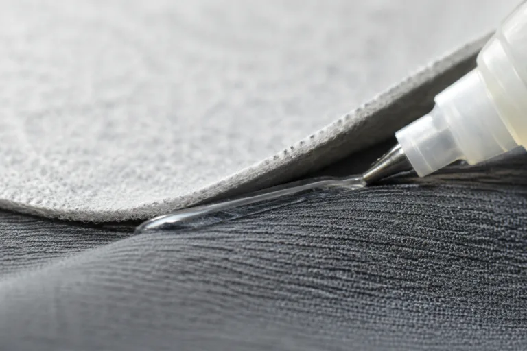 Professional industrial product close-up showing fabric-to-fabric bonding with realistic woven and knitted textile textures, clean adhesive application, and soft flexible material behavior.