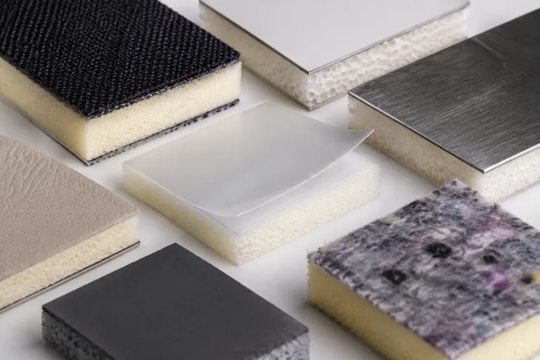 Foam Adhesive 12 A realistic close-up product photo showing foam bonded with different materials used for adhesive selection testing, including fabric, plastic, metal, flexible film, and soft composite surfaces.