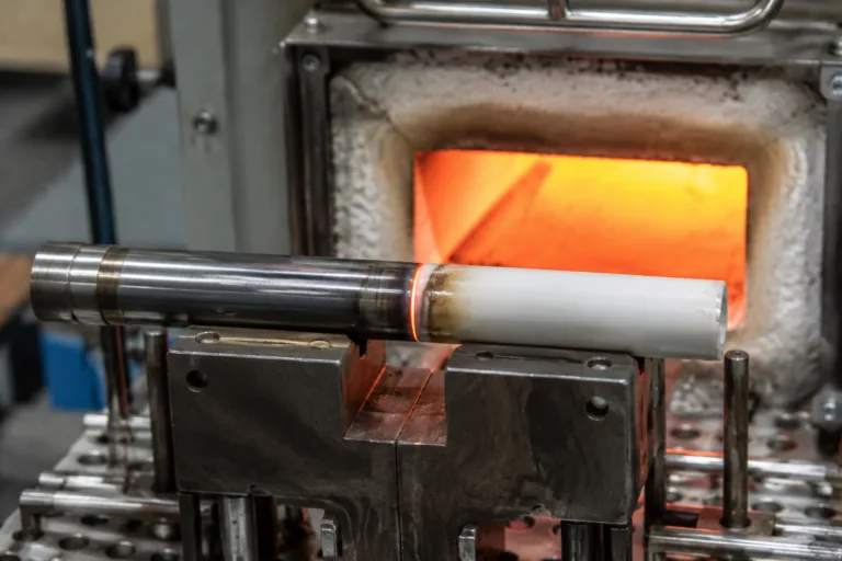 Ceramic Adhesive 12 A realistic industrial lab close-up of ceramic and metal components bonded together and exposed to controlled heat, illustrating ceramic adhesive heat resistance and thermal durability.