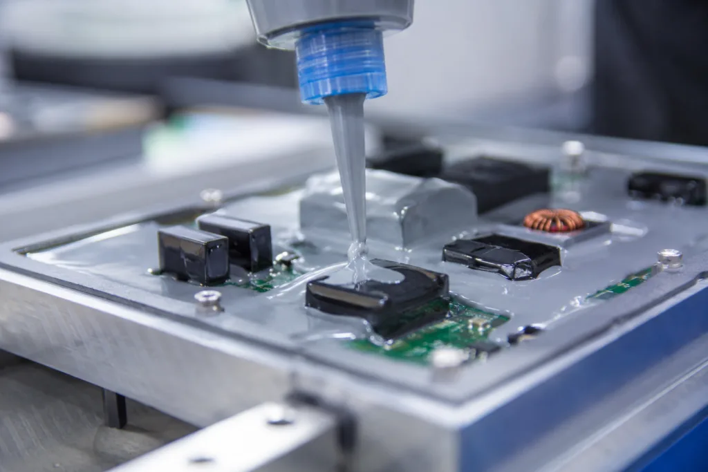 Insulation Adhesive 1 A realistic close-up scene showing industrial insulation adhesive application on electronic components for electrical protection in a modern electronics manufacturing environment.