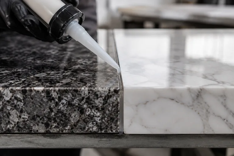 Stone Adhesive 4 A realistic close-up image of marble and granite slabs being bonded with adhesive, highlighting a clean controlled seam in a professional stone fabrication environment.