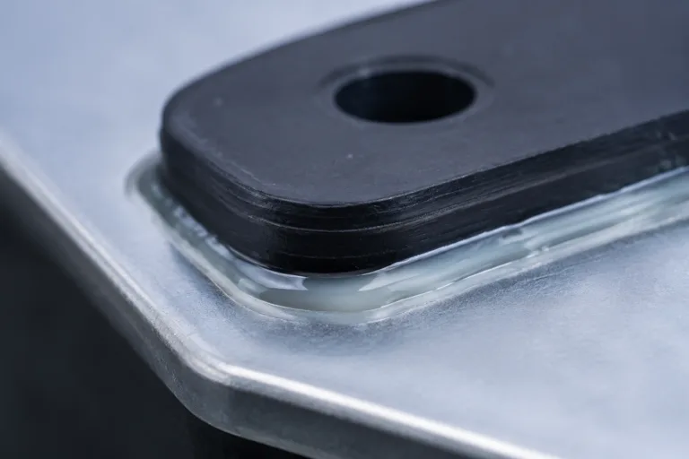 Metal Adhesive 7 A realistic close-up of metal-to-rubber bonding adhesive application in an industrial sealing and assembly context, highlighting the adhesive layer between a rubber component and a metal surface.