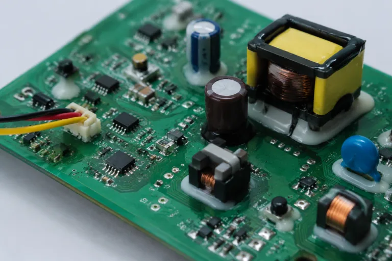 PCB Adhesive 11 A clean industrial close-up of a circuit board featuring multiple component types that require different adhesive reinforcement approaches, presented in a professional technical style.