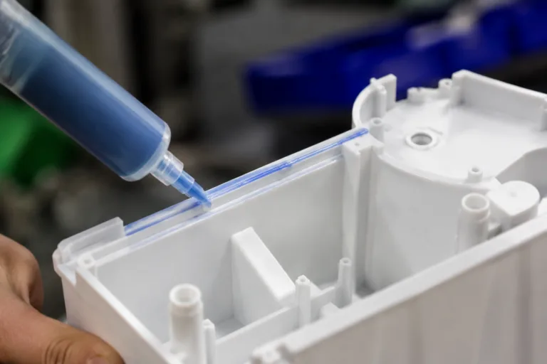Bonding Adhesive 4 A realistic close-up of adhesive being applied to ABS or PC plastic housing components during electronics or appliance manufacturing, showing a visible glue line and precise industrial assembly.