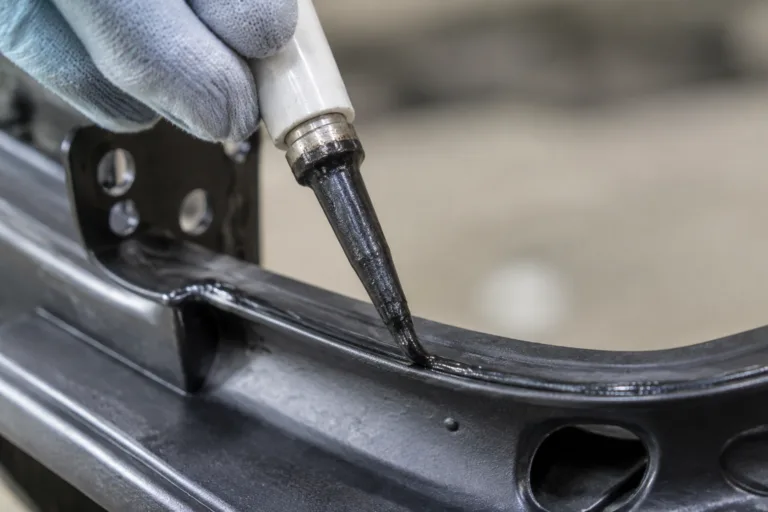 Bonding Adhesive 6 A realistic manufacturing close-up showing rubber bonding adhesive applied during sealing and assembly, with a visible flexible bond between a rubber gasket or strip and a metal or rubber component.